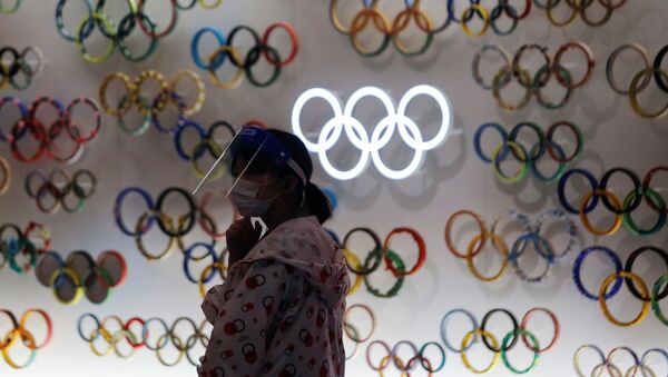 Una chica con mascarilla cerca de logo de Juegos Olímpicos (JJOO) en Tokio durante el brote de coronavirus en Japón - Sputnik Mundo