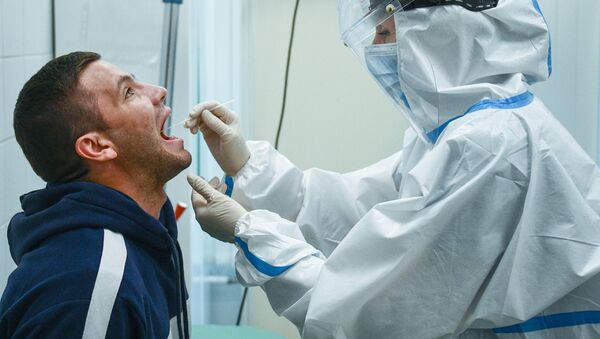 El personal médico recoge el material biológico para hacer una prueba de COVID-19 - Sputnik Mundo