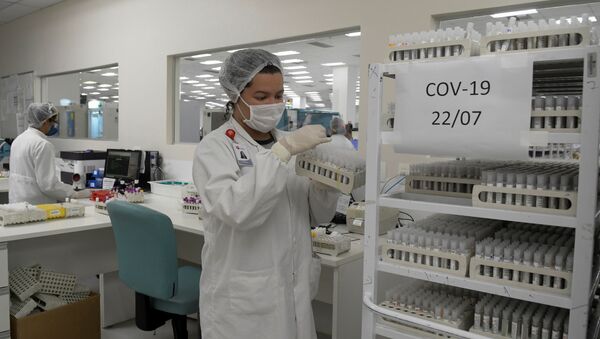 Un empleado encargado de los tests de COVID-19 en un laboratorio en Brasil - Sputnik Mundo