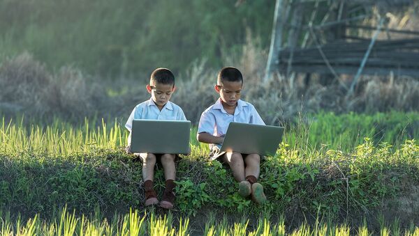Dos niños usando ordenadores portátiles - Sputnik Mundo