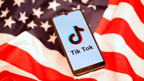 Un 'smartphone' con el logo de TikTok en la pantalla encima de una bandera estadounidense - Sputnik Mundo