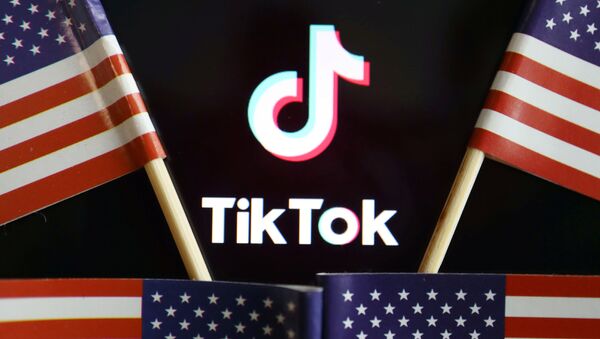 El logo de TikTok junto a banderas estadounidenses - Sputnik Mundo
