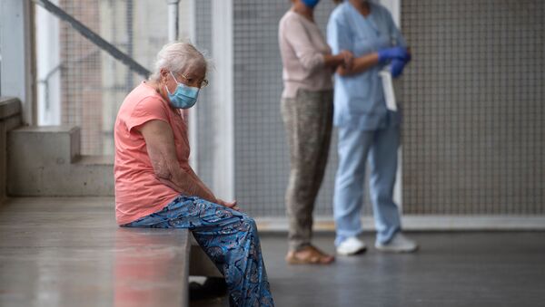 Una anciana espera ser examinada en un centro médico - Sputnik Mundo