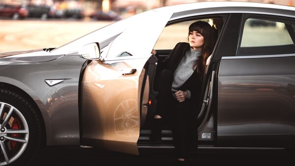 Una mujer en el interior de un vehículo de la marca Tesla - Sputnik Mundo