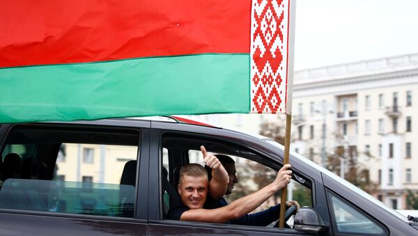 Un hombre ondea la bandera nacional bielorrusa desde la ventana de un automóvil en Minsk, Bielorrusia - Sputnik Mundo