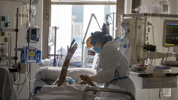 Trabajadores sanitarios asisten a un paciente con COVID-19  - Sputnik Mundo