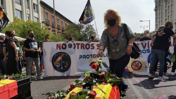 Manifestante depositando una flor sobre un ataúd durante la concentración de la policía española - Sputnik Mundo