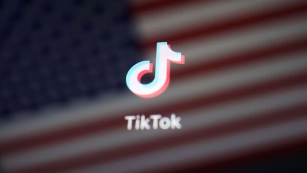 Logo de TikTok sobre una bandera de los Estados Unidos - Sputnik Mundo