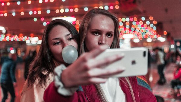 Dos chicas con un smartphone (imagen referencial) - Sputnik Mundo