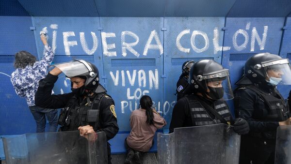 Los manifestantes hacen un graffiti en una valla metálica que rodea la estatua de Cristobal Colón para su protección, CDMX - Sputnik Mundo