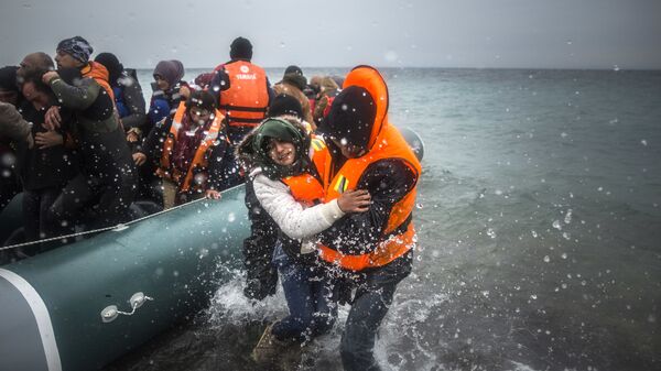Refugiados y migrantes desembarcan en una playa después de cruzar una parte del mar Egeo desde Turquía hasta la isla griega de Lesbos - Sputnik Mundo