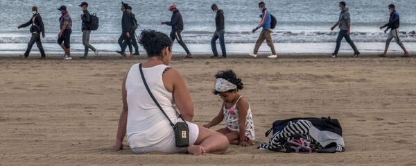 Migrantes caminan por la orilla escoltados por la Policía española tras llegar a la costa de Canarias. 20 de octubre de 2020 Migrantes caminan por la orilla escoltados por la Policía española tras llegar a la costa de Canarias. 20 de octubre de 2020 - Sputnik Mundo