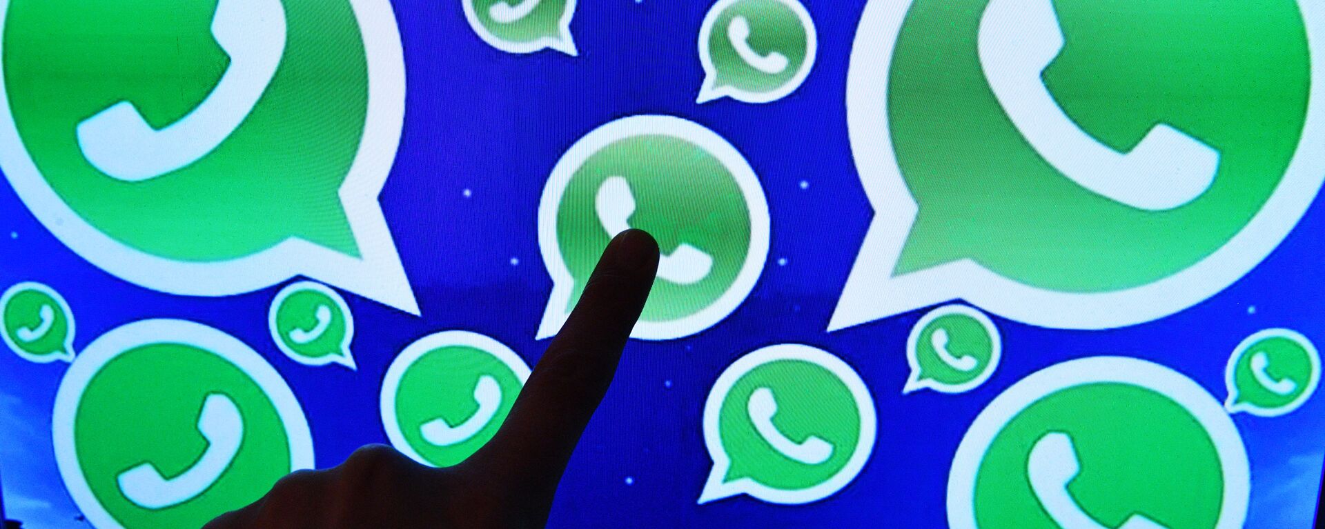 Una persona toca una pantalla en la que se ven diversos logotipos de la aplicación WhatsApp - Sputnik Mundo, 1920, 11.05.2021