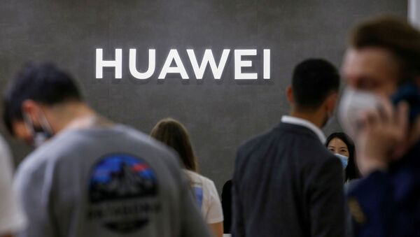 Unas personas caminan delante del estand de Huawei en una feria de tecnología (archivo) - Sputnik Mundo