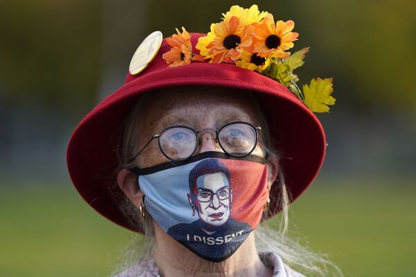Женщина в маске с портретом судьи Верховного суда Рут Бейдер Гинзбург во время акции протеста в Портленде - Sputnik Mundo
