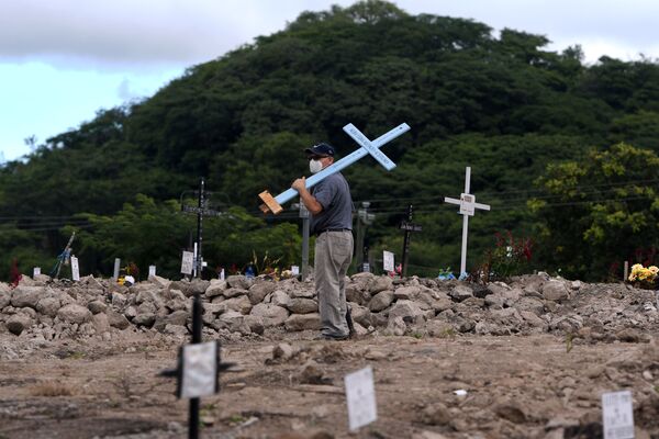 Мужчина с крестом на кладбище «Covid-19» в День мертвых в Гондурасе - Sputnik Mundo