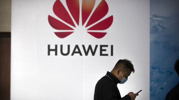Una persona camina delante del logotipo de Huawei en una feria tecnológica en Pekín - Sputnik Mundo