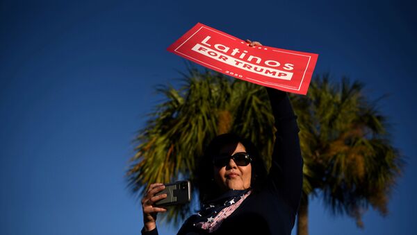 Una mujer sostiene un cartel que dice 'latinos por Trump' - Sputnik Mundo