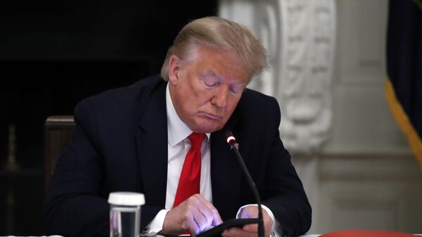 Donald Trump, expresidente de Estados Unidos, mira su teléfono - Sputnik Mundo