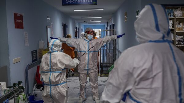 Un miembro del equipo médico es desinfectado antes de salir de la sala COVID-19 del hospital Severo Ochoa en Leganés, en las afueras de Madrid, España.  - Sputnik Mundo