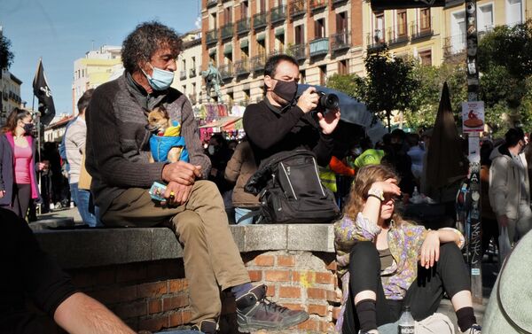 Varias personas reposan en la Plaza de Cascorro de Madrid durante el primer domingo del Rastro - Sputnik Mundo