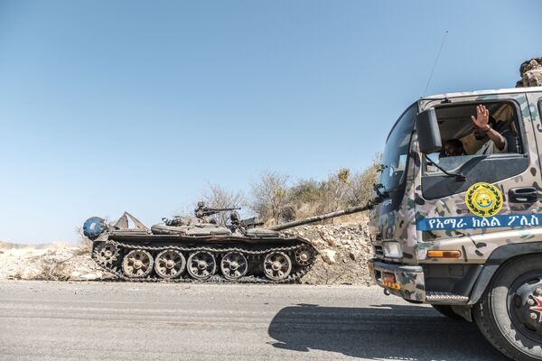 Брошенный на дороге танк и проезжающий мимо грузовик спецназа Амхара возле Хумеры, Эфиопия - Sputnik Mundo