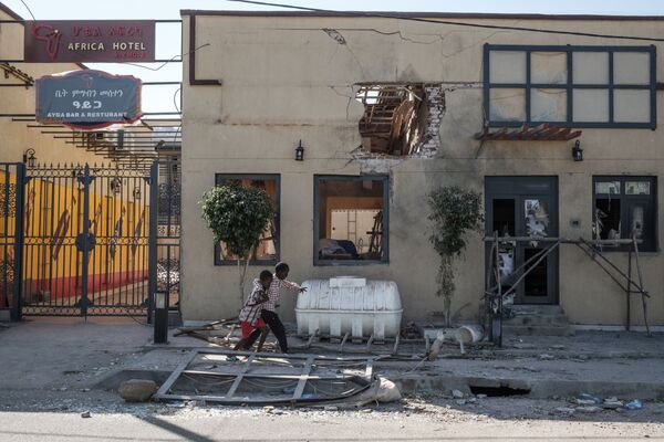 Дети играют перед гостиницей, поврежденной минометным обстрелом, в Хумере, Эфиопия - Sputnik Mundo