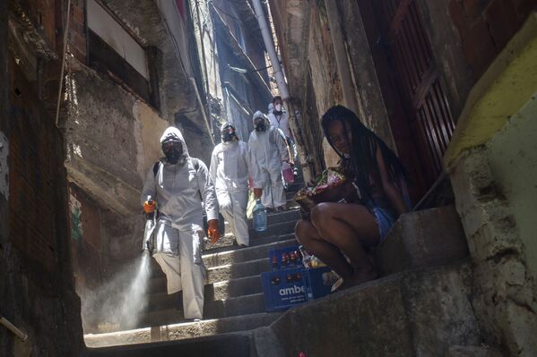 Unos voluntarios rocían desinfectante en los barrios marginales de Río de Janeiro, Brasil. - Sputnik Mundo