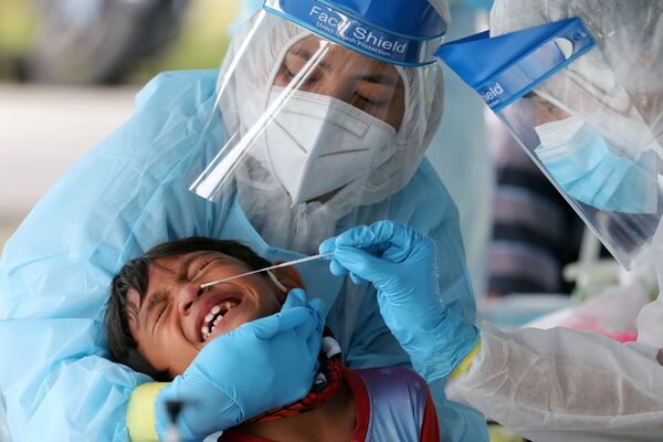 El personal sanitario realiza una prueba de COVID-19 a un niño en una ciudad de Klang, en Malasia. - Sputnik Mundo