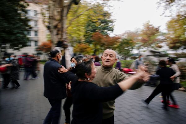 El mundo entero continúa preguntándose cómo los chinos han logrado volver a la vida normal tan rápido y por qué no tienen una segunda ola de contagios En la foto: los residentes bailan en uno de los parques de Wuhan.  - Sputnik Mundo