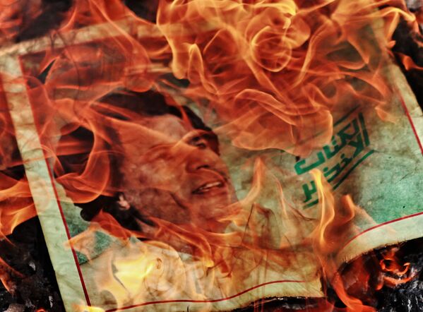 A partir de mayo de 2012 las revoluciones consiguieron derrocar a los jefes de Estado Túnez, Egipto, Libia y Yemen. En la foto: Los manifestantes queman un retrato del líder libio Muammar Gaddafi - 2 de marzo de 2011. - Sputnik Mundo