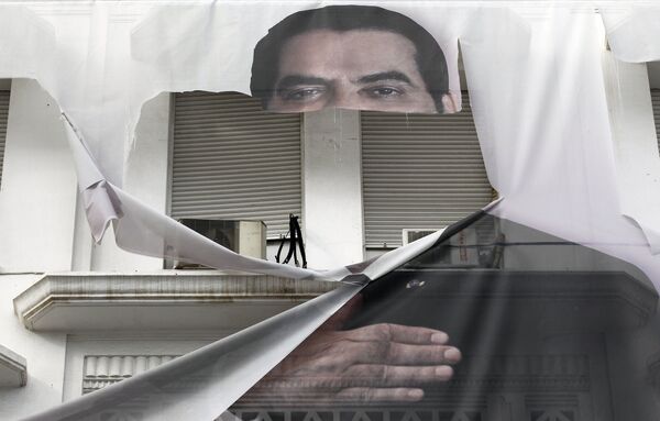 El entonces presidente de Túnez, Zine El Abidine Ben Ali, huyó a Arabia Saudí junto a su familia luego de que fuera forzado a dimitir el 14 de enero de 2011. En la foto: un cartel rasgado con la imagen del presidente tunecino Zine El Abidine Ben Ali - 16 de enero de 2011. - Sputnik Mundo