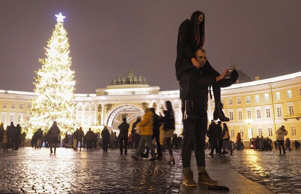 Una pareja se toma una foto en la Plaza del Palacio durante la celebración de Año Nuevo en el centro de San Petersburgo (Rusia). - Sputnik Mundo