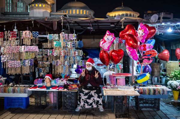 Una vendedora ambulante en la plaza Taksim en Estambul (Turquía) la última noche del año 2020. El Gobierno del país anunció medidas de confinamiento de cuatro días, entre el 31 de diciembre y el 4 de enero, para evitar la propagación del coronavirus en las tradicionales celebraciones masivas de Año Nuevo. - Sputnik Mundo