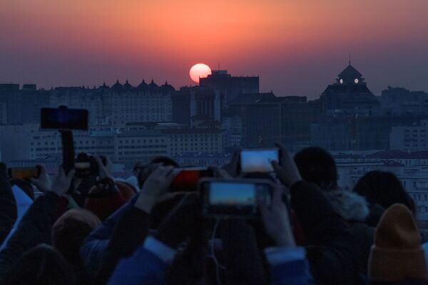 Unas personas toman fotografías del primer amanecer del año nuevo en Pekín (China) el 1 de enero. - Sputnik Mundo