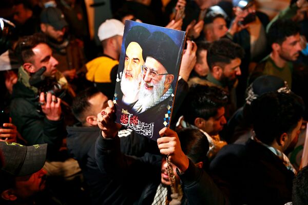 Miembros de las Fuerzas de Movilización Popular (PMF) y sus partidarios corean consignas contra Estados Unidos en el aeropuerto internacional de Bagdad (Irak) durante las conmemoraciones del primer aniversario de los asesinatos de Qasem Soleimani y Abu Mahdi Muhandis. - Sputnik Mundo