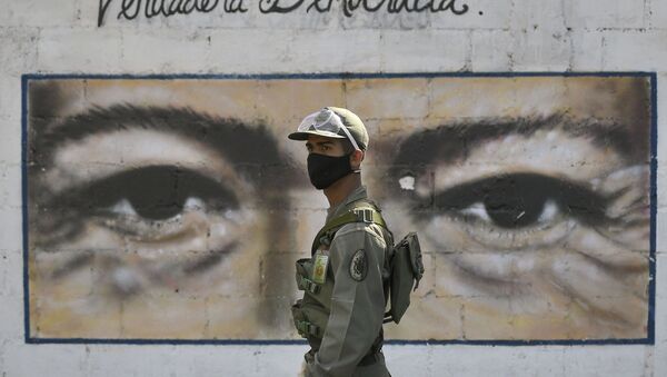 Un soldado frente al mural con los ojos de Hugo Chávez en Caracas, Venezuela - Sputnik Mundo