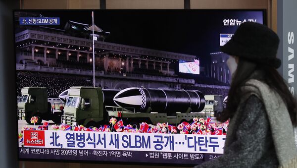 Una mujer ve por la televisión el desfile militar celebrado en Pyongyang  - Sputnik Mundo