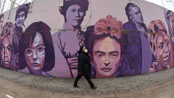 Una persona camina junto a un mural en homenaje a mujeres emblemáticas en Madrid  - Sputnik Mundo