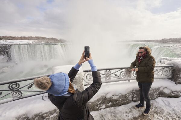 Un par de turistas se toma fotografías en un mirador cercano a la cascada Horseshoe en Ontario, Canadá. - Sputnik Mundo