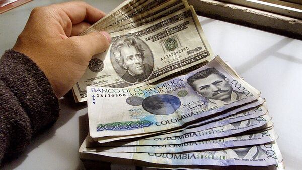 Pesos colombianos y dólares - Sputnik Mundo