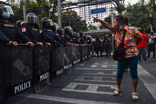 Una manifestante gesticula a la policía antidisturbios en Bangkok (Tailandia), cerca de donde unos migrantes de Birmania se manifestaban contra el golpe militar que tuvo lugar en su tierra natal. - Sputnik Mundo