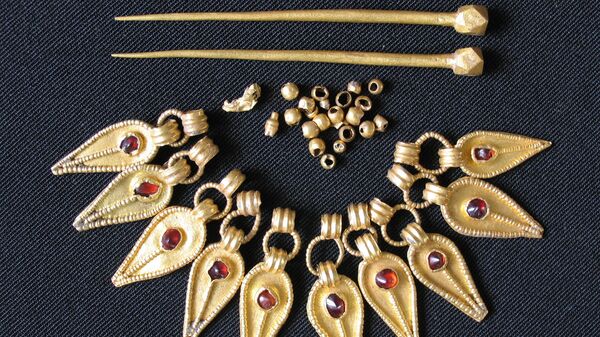 Fotografía de las piezas de un collar y par de agujas procedentes de la sepultura - Sputnik Mundo