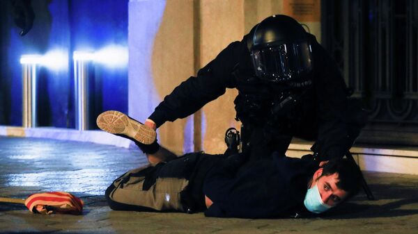 Un policía deteniendo a un manifestante durante los disturbios en Barcelona, España - Sputnik Mundo