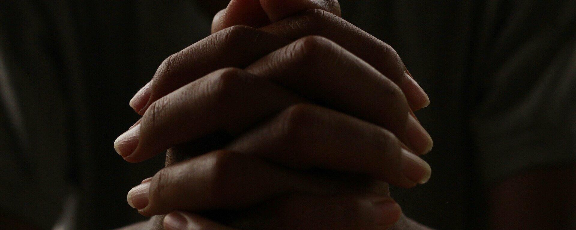Una persona rezando con las manos entrelazadas - Sputnik Mundo, 1920, 03.03.2021