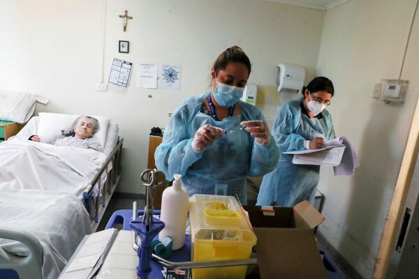 El personal sanitario aplica la vacuna china Sinovac a los residentes de un hogar de ancianos en Santiago de Chile. - Sputnik Mundo