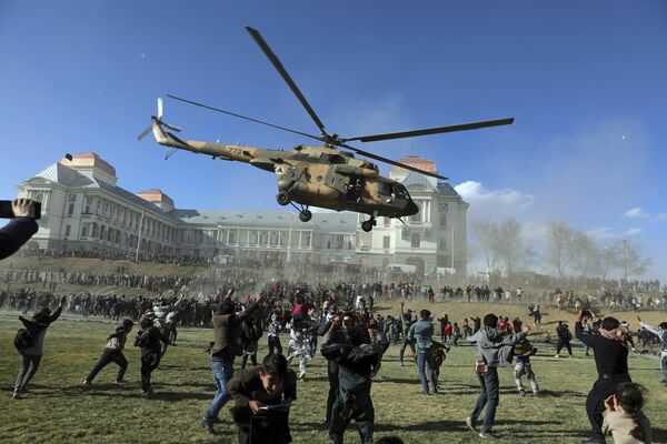 Un helicóptero militar vuela sobre los visitantes de la exposición Afghan Security Forces Exhibition que se celebra en el territorio del Palacio Darul Aman en la ciudad de Kabul. - Sputnik Mundo