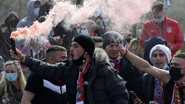 Un aficionado del Atlético enciende una bengala de humo fuera del estadio Wanda Metropolitano de Madrid el 7 de marzo de 2021.  - Sputnik Mundo