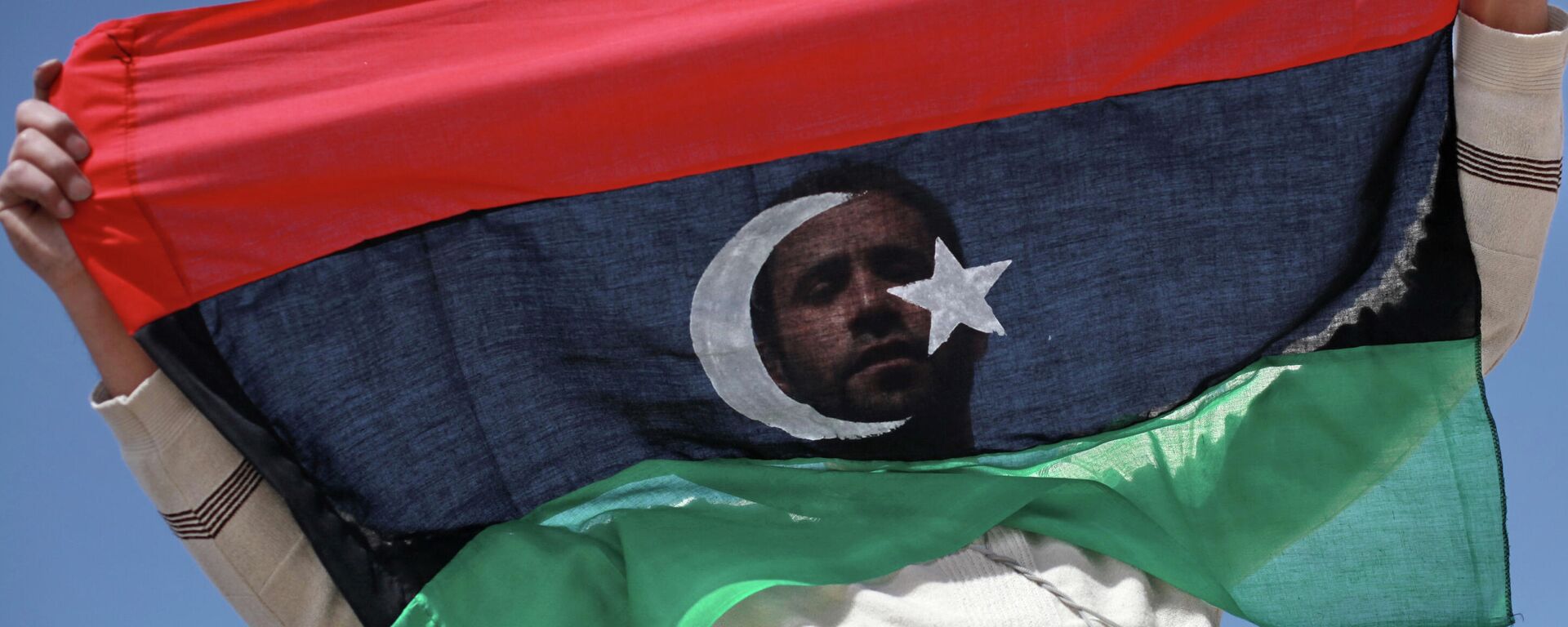 Un opositor con la bandera de Libia - Sputnik Mundo, 1920, 21.09.2021