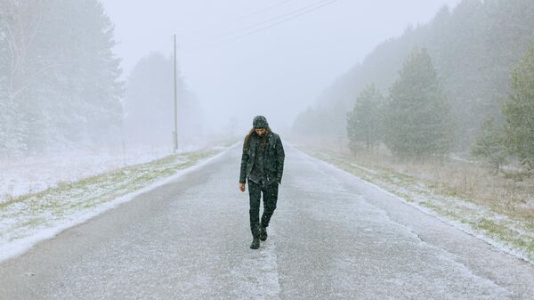 Una persona camina por una calle invernal - Sputnik Mundo
